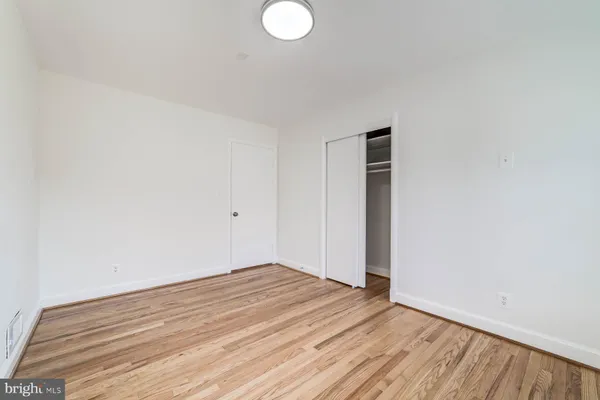 a view of empty room with wooden floor