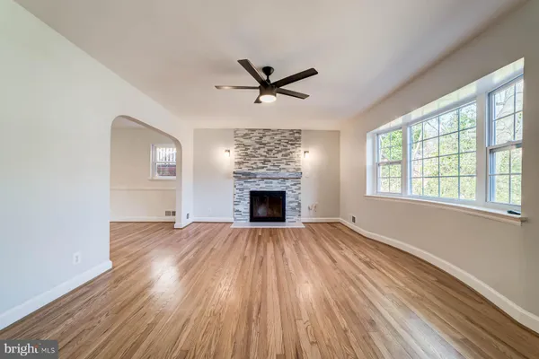 an empty room with windows fireplace and a sink