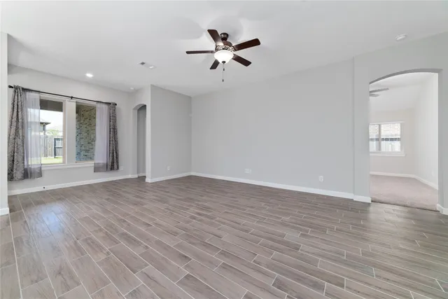 a view of an empty room with window and wooden floor