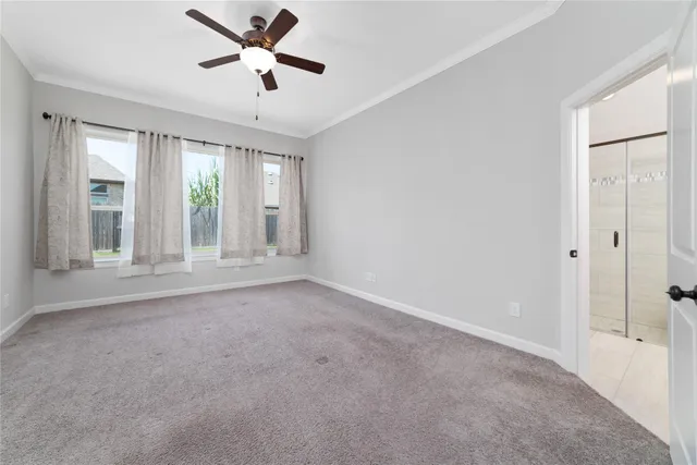 an empty room with windows and ceiling fan
