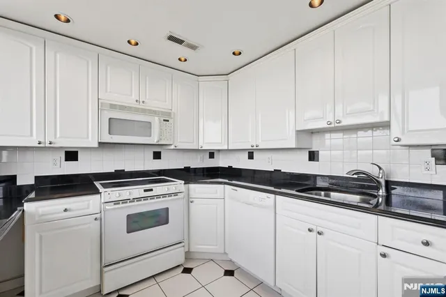 a kitchen with white cabinets and white appliances