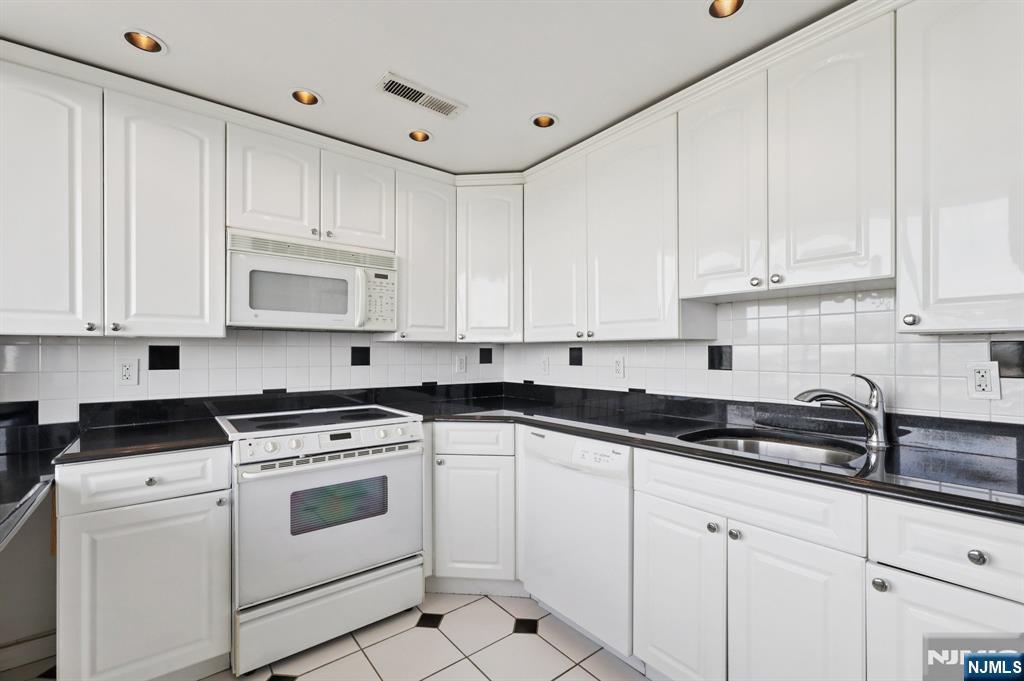 151 Prospect Avenue, Unit 18A Hackensack, NJ 07601 - Photo 12 of 19 a kitchen with white cabinets and white appliances