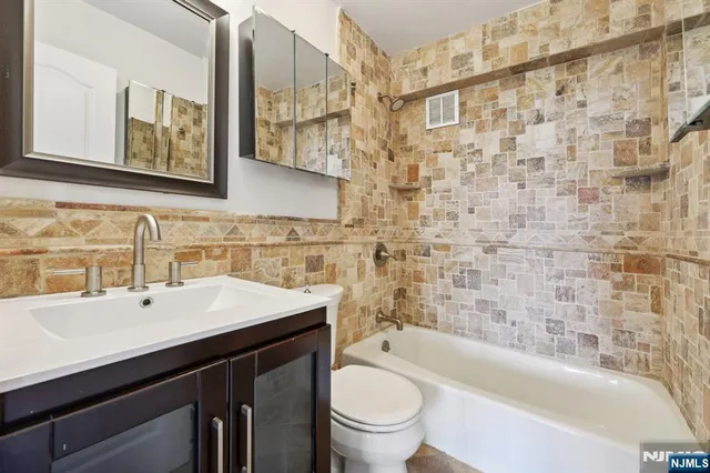 a bathroom with a sink a toilet and bathtub