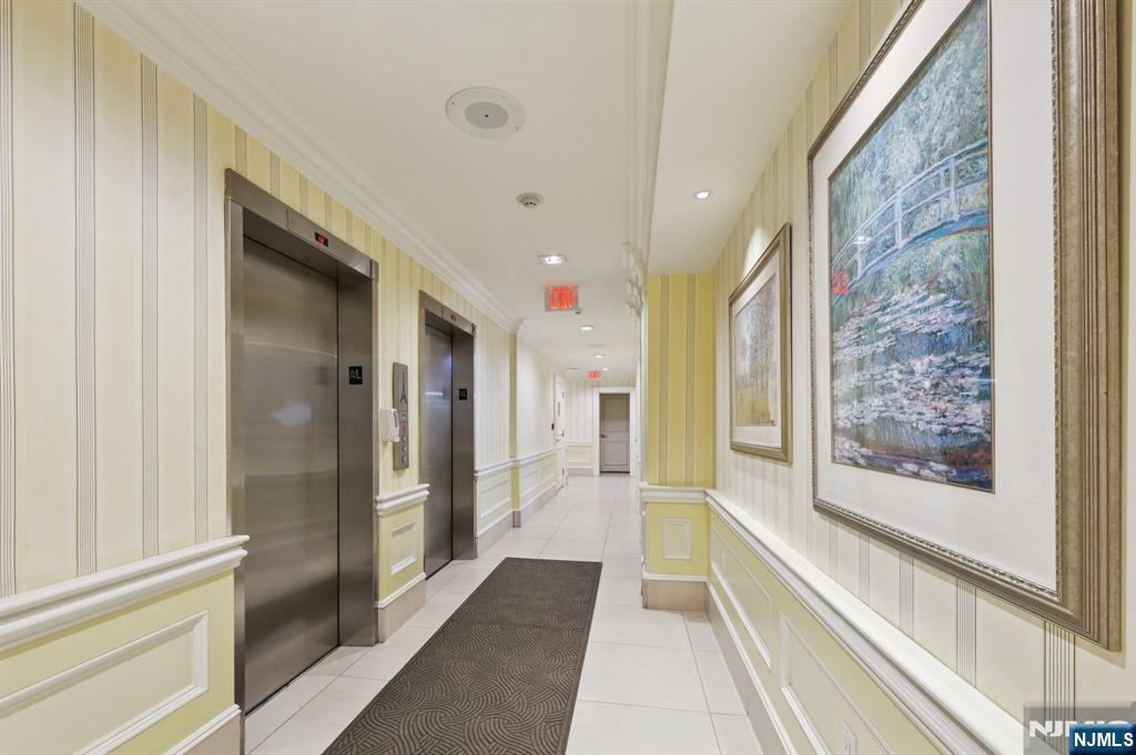 151 Prospect Avenue, Unit 18A Hackensack, NJ 07601 - Photo 3 of 19 a bathroom with a glass shower door and a bathtub