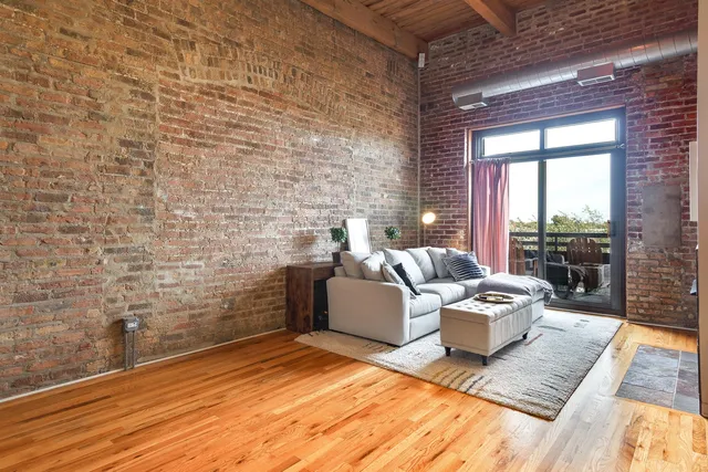 a living room with couches rug and a table with wooden floor