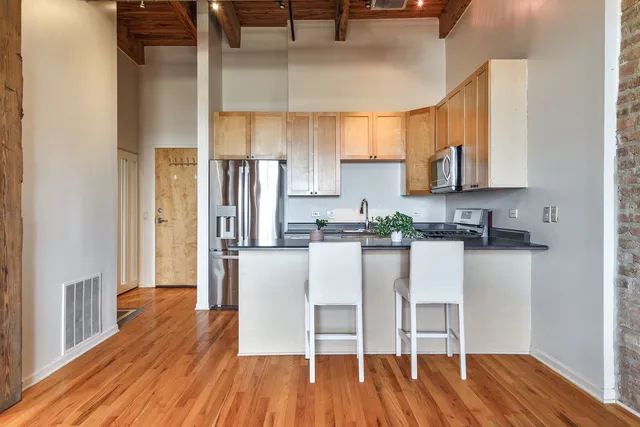 a kitchen with stainless steel appliances granite countertop a refrigerator and microwave