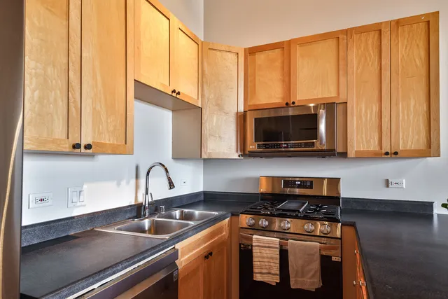 a kitchen with stainless steel appliances a sink a stove and a microwave