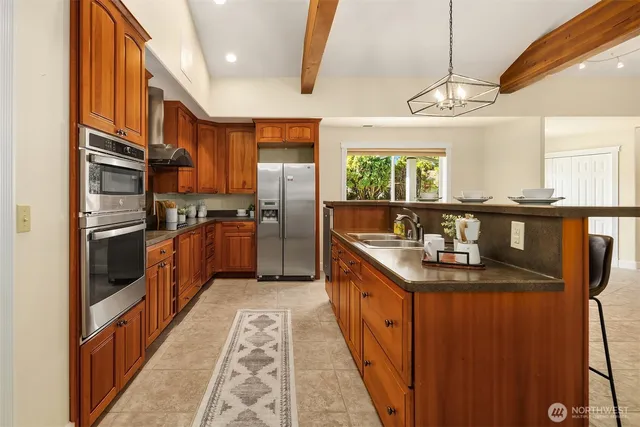 a kitchen with stainless steel appliances granite countertop a sink a stove and a refrigerator