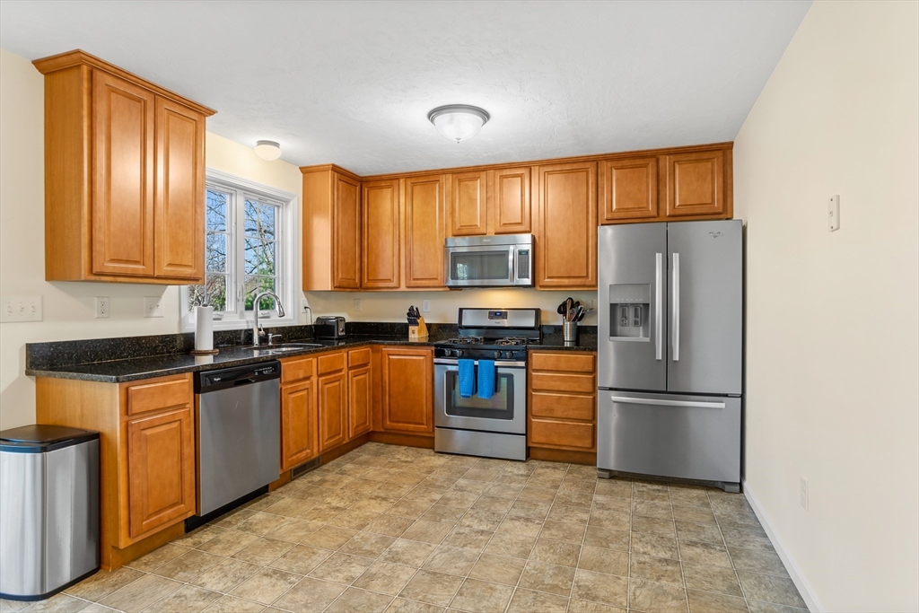41 Boston Road, Unit 433 Billerica, MA 01862 - Photo 4 of 23 a kitchen with stainless steel appliances granite countertop a refrigerator stove top oven and sink