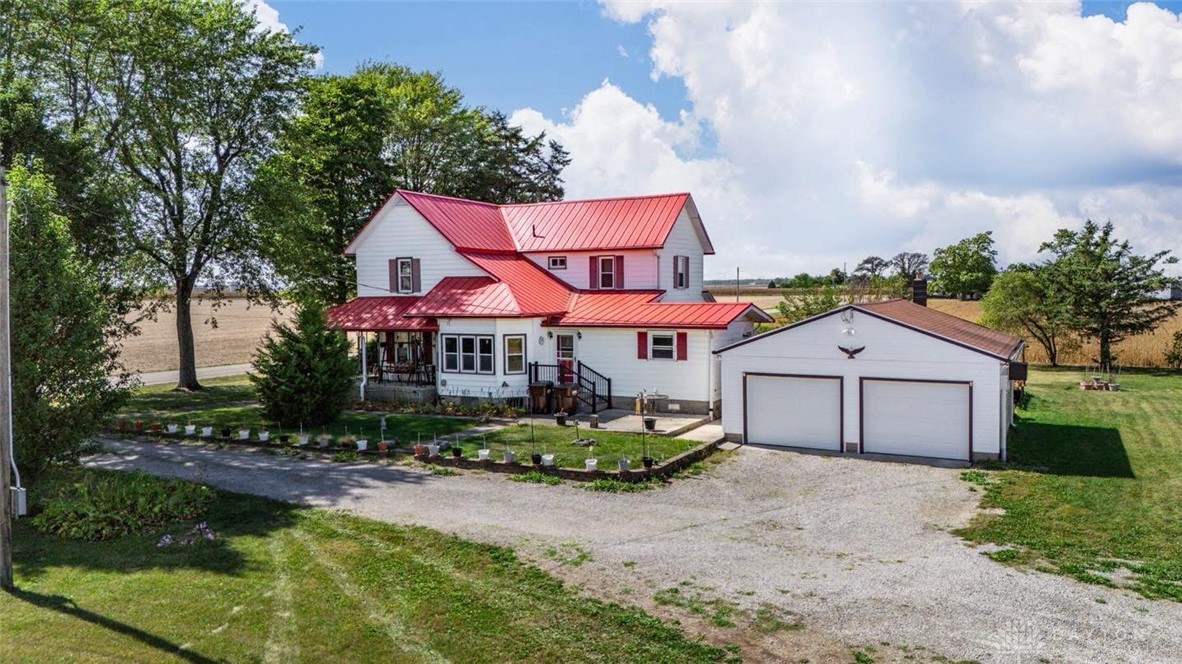 7404 Grubbs-Rex Road Arcanum, OH 45304 - Photo 2 of 40 This charming two-story residence features a vibrant red roof, a spacious porch, and an
detached two-car garage.