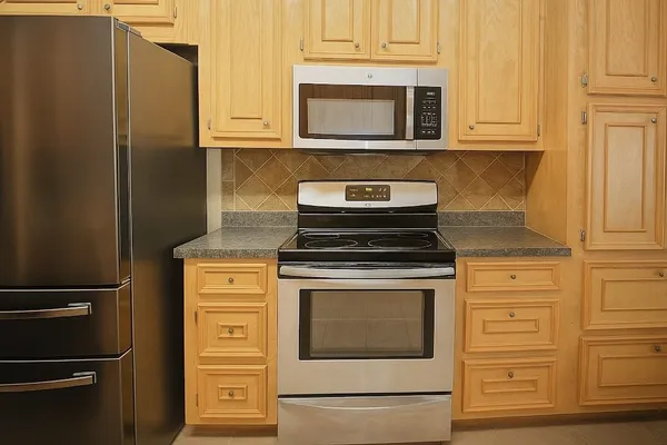 a kitchen with stainless steel appliances granite countertop a refrigerator stove and cabinets