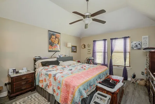 a bedroom with a bed and a dresser next to a window