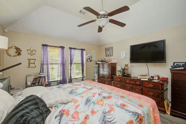 a bedroom with a bed and a flat tv screen on dresser