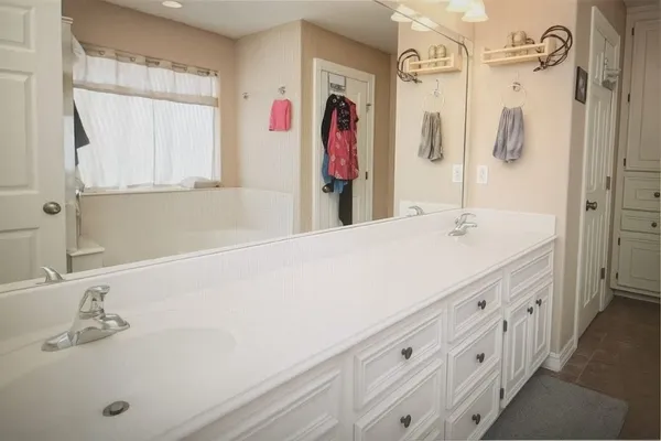 a bathroom with a double vanity sink a mirror and a shower