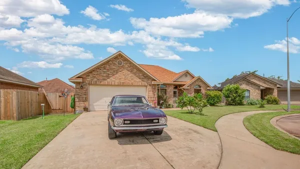 a car parked in front of a house with a garden