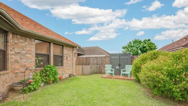 a backyard of a house with table and chairs and potted plants