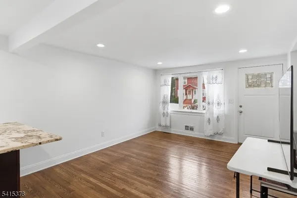 a view of an empty room with wooden floor