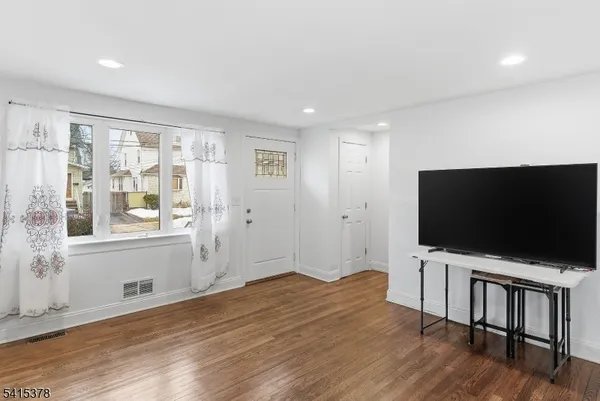 a view of a livingroom with wooden floor and furniture