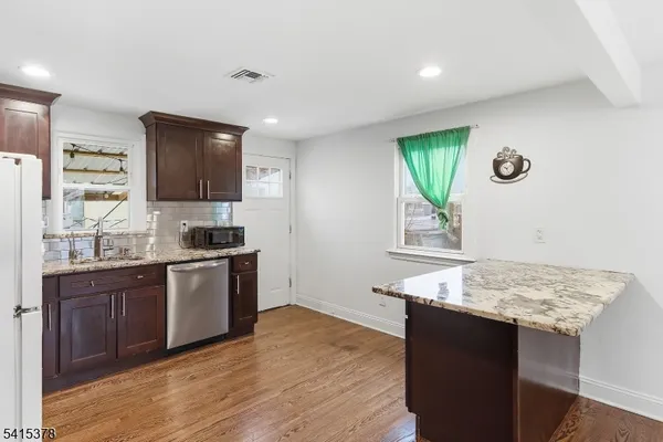 a kitchen with a refrigerator sink and cabinets