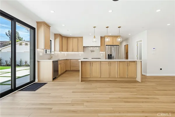 a large kitchen with cabinets and a wooden floor
