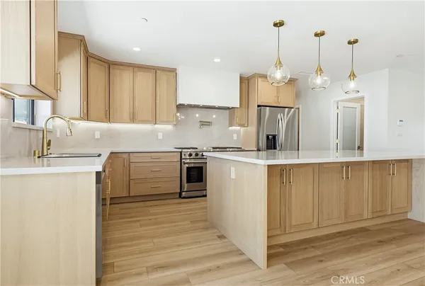 a kitchen with kitchen island a sink a counter top space stainless steel appliances and cabinets