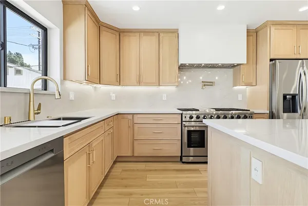 a kitchen with stainless steel appliances granite countertop a sink stove and refrigerator