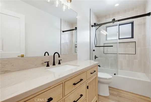 a bathroom with a granite countertop sink a toilet and shower