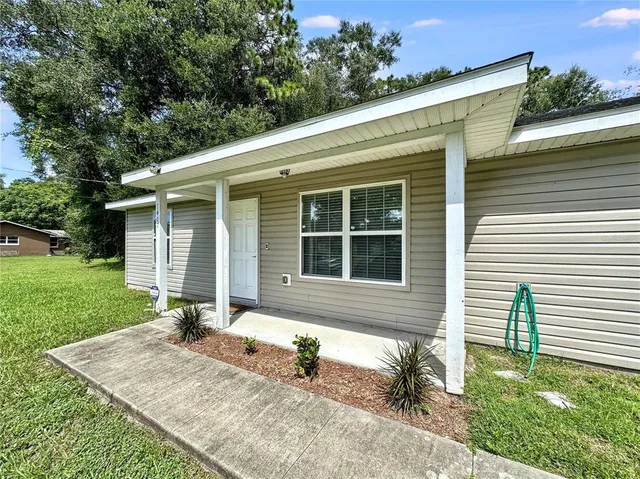 a front view of a house with a yard and outdoor seating