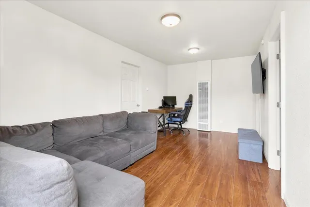 a living room with furniture and a wooden floor