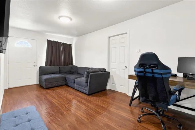 a living room with furniture and a wooden floor