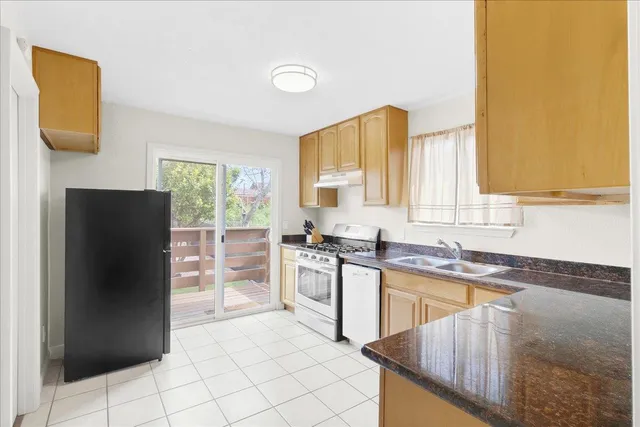 a kitchen with stainless steel appliances granite countertop a refrigerator sink and stove