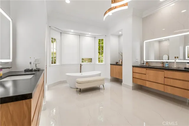 a spacious bathroom with a tub sink and mirror