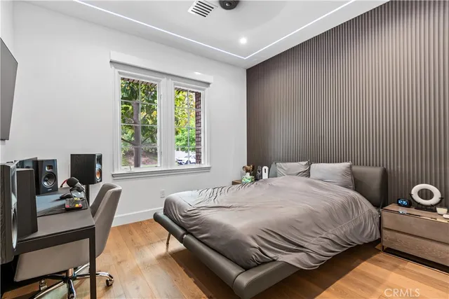 a bedroom with a bed and a desk next to a window