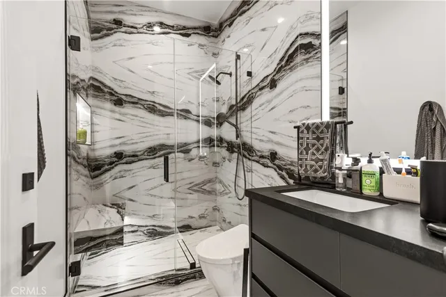 a bathroom with a granite countertop sink a mirror and shower