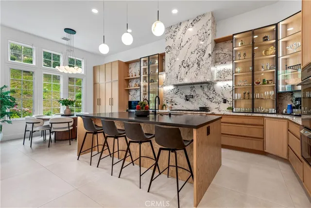 a kitchen with stainless steel appliances kitchen island granite countertop a table and chairs in it