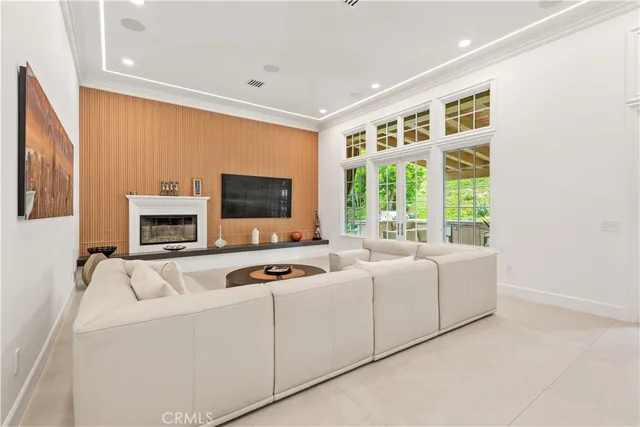 a living room with furniture a flat screen tv and a window