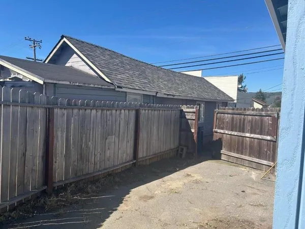 a view of a house with wooden fence