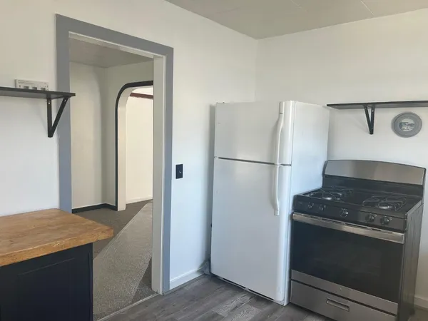 a kitchen with a refrigerator and a stove top oven