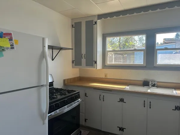 a kitchen with a sink stove top oven and cabinets