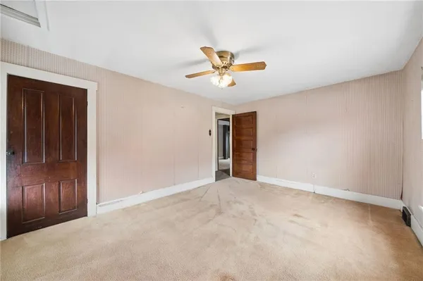 an empty room with closet and chandelier fan