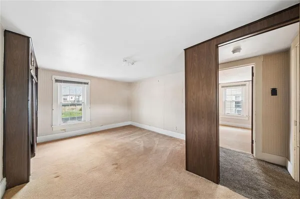 an empty room with windows and closet