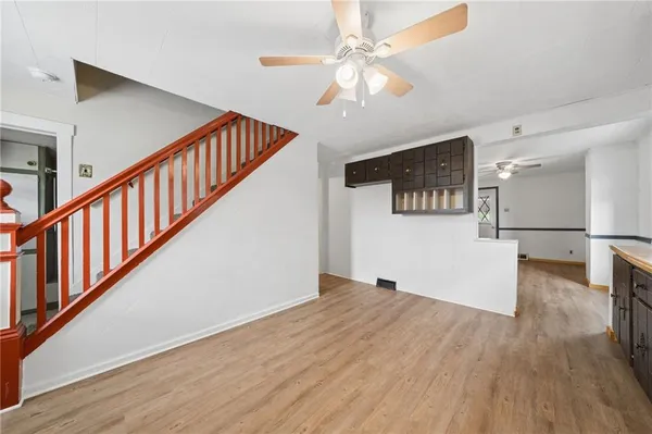 a view of a hallway with wooden floor and staircase