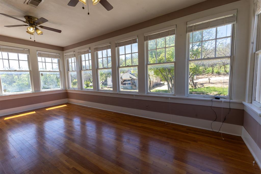 1115 Austin Street Coleman, TX 76834 - Photo 25 of 40 a view of an empty room with wooden floor and a window