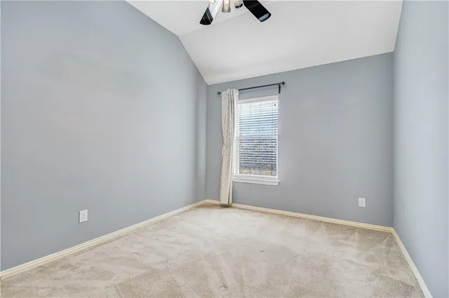 an empty room with a ceiling fan and a window