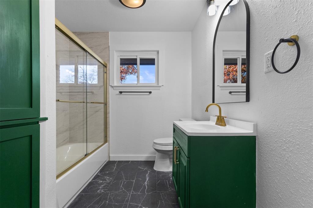 924 Whitestone Lane Dallas, TX 75232 - Photo 18 of 32 a bathroom with a toilet sink and mirror