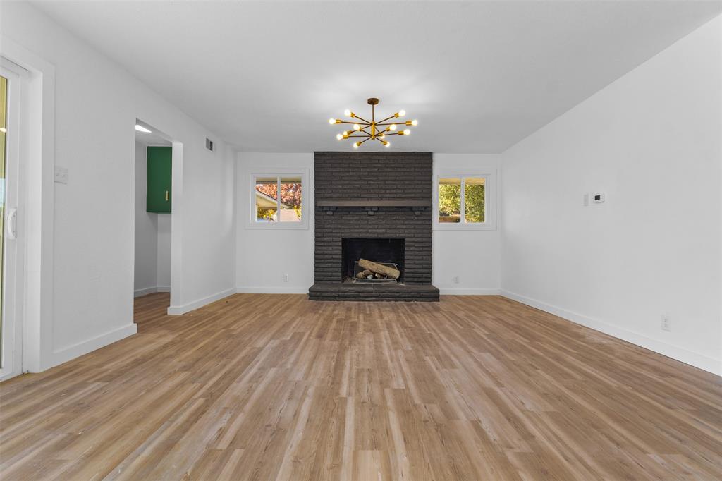 924 Whitestone Lane Dallas, TX 75232 - Photo 9 of 32 a view of livingroom with a fireplace a chandelier and wooden floor
