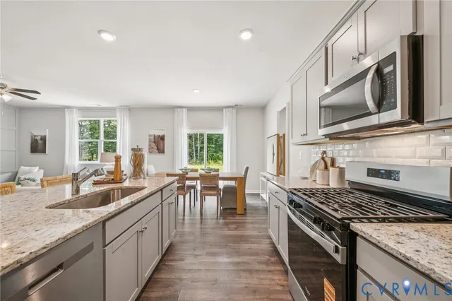 a kitchen with stove a sink and chairs