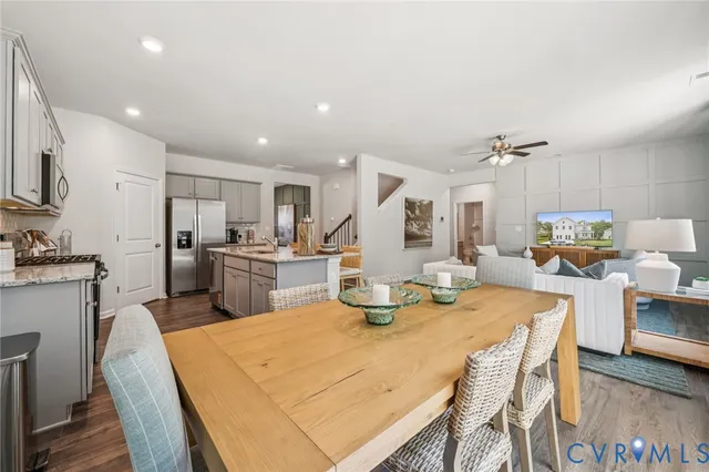 a kitchen with a dining table chairs and refrigerator