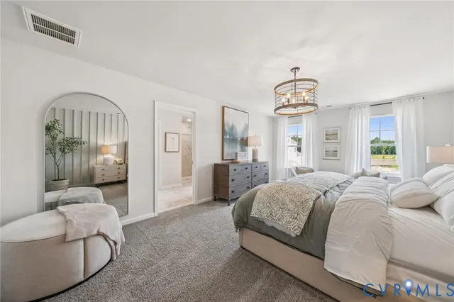 a spacious bedroom with a bed and a chandelier