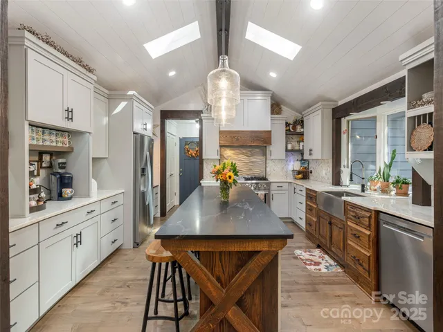 a kitchen with stainless steel appliances granite countertop a kitchen island a stove a sink dishwasher a dining table and chairs with wooden floor